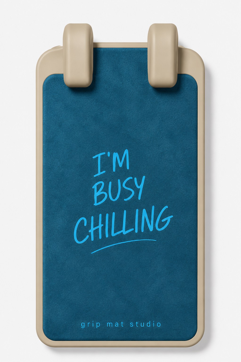 A rectangular grip mat with rounded corners and two beige plastic loops at the top, featuring a dark teal blue center panel with the text 'I'M BUSY CHILLING' in light blue and 'grip mat studio' at the bottom, shown on a light gray background.