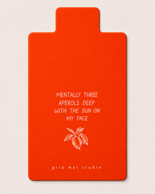 Aperol orange Amalfi Pilates reformer grip mat by Grip Mat Studio. The text reads 'MENTALLY THREE APEROLS DEEP WITH THE SUN ON MY FACE' and 'grip mat studio' is printed at the bottom.