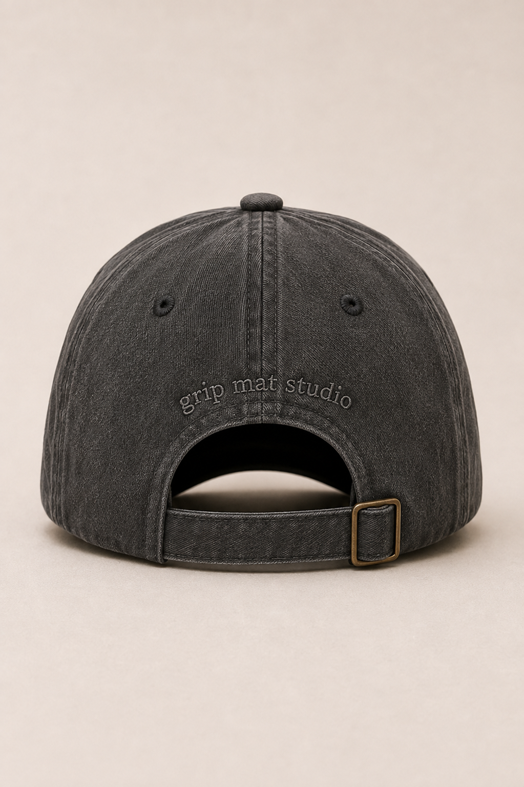Back view of charcoal Pilates hat with tonal Grip Mat Studio embroidery